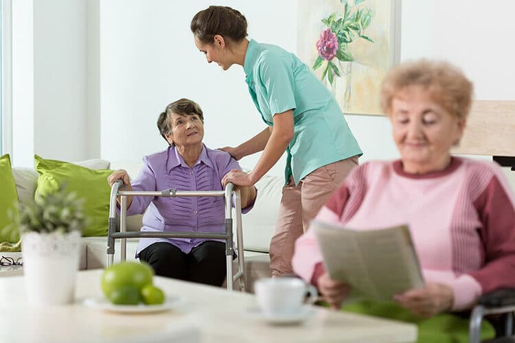 Carer helping a mature lady stand at home